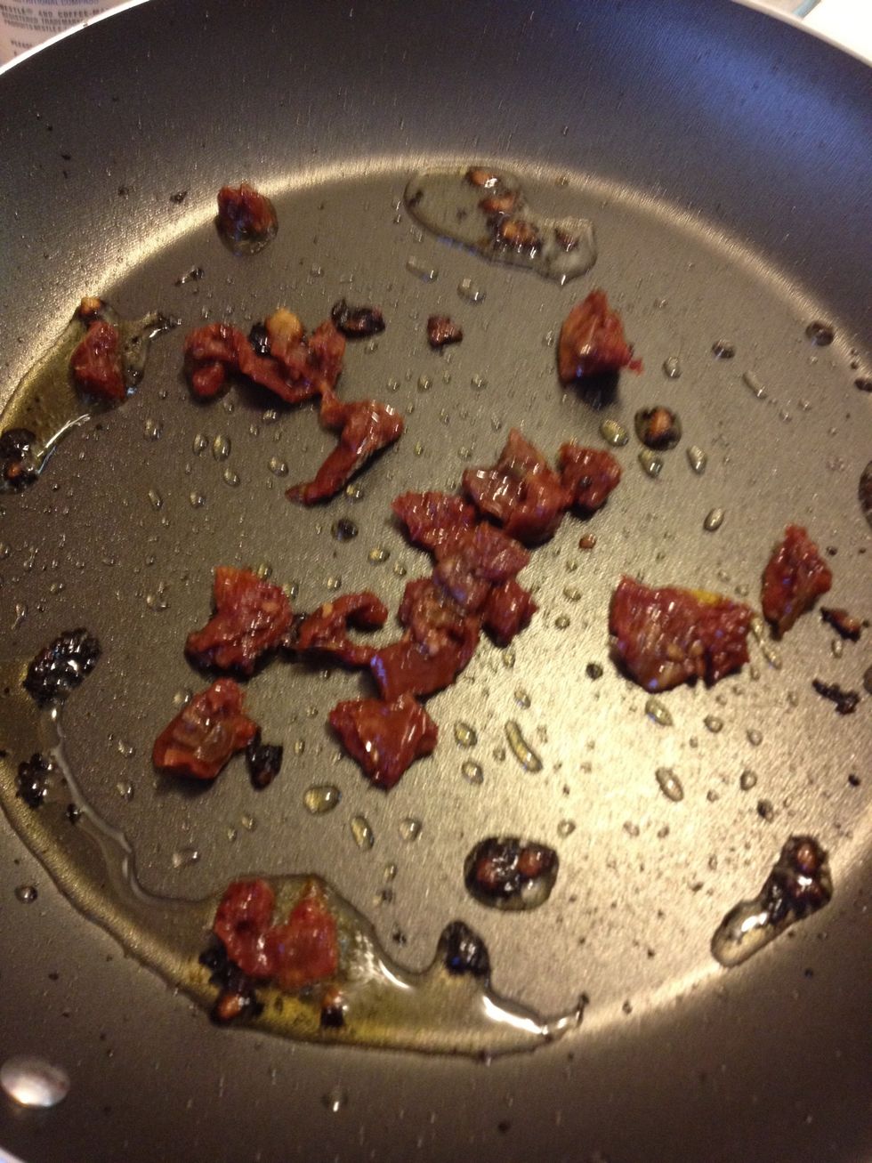 When the garlic is cooked, add cut up sun-dried tomatoes to pan and cook.