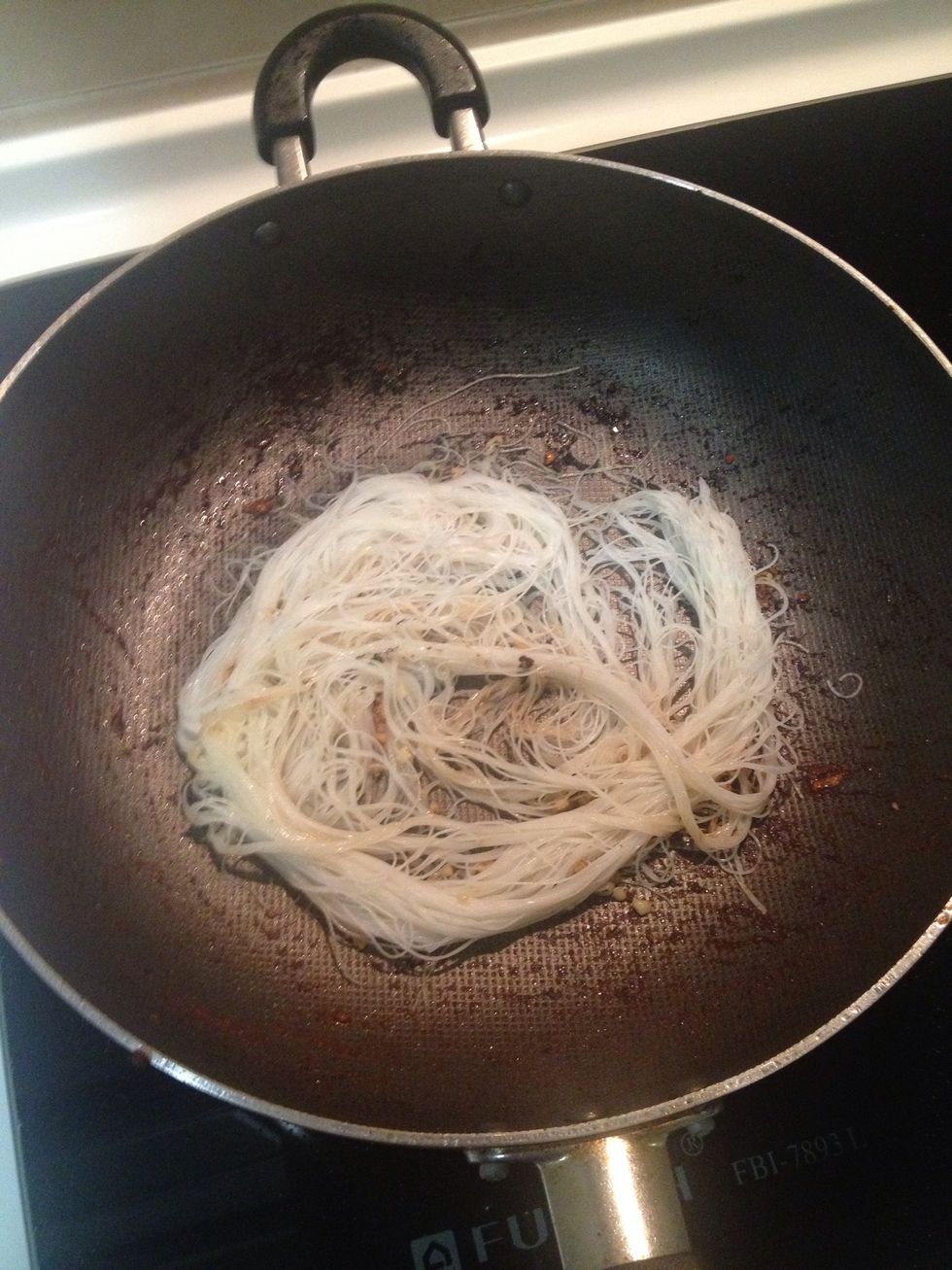 When the garlic turn golden brown, add the rice vermicelli in.