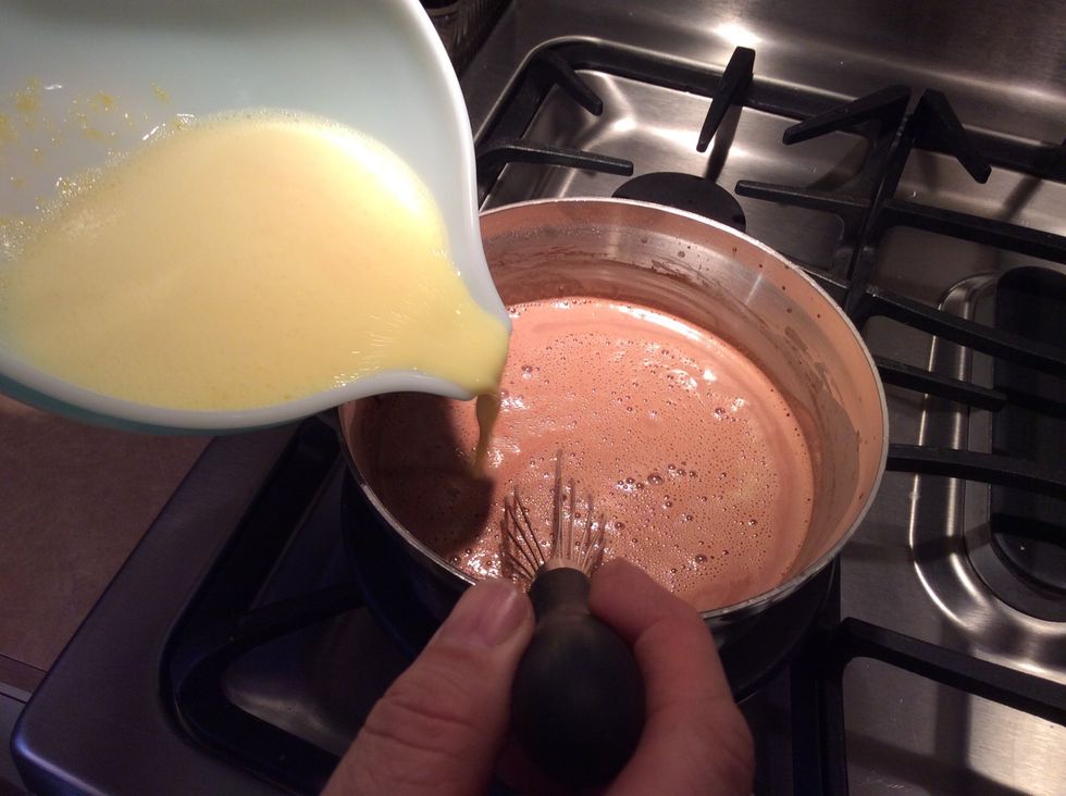 When the half and half mixture is hot but not boiling, slowly pour in the milk and egg yolk mixture. Whisking constantly.