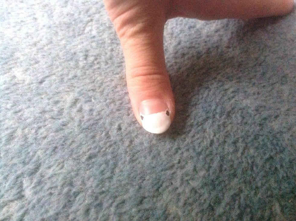 When the head is completely dry begin to add its features. For the ears draw two small triangles in the centre of the previous ones.