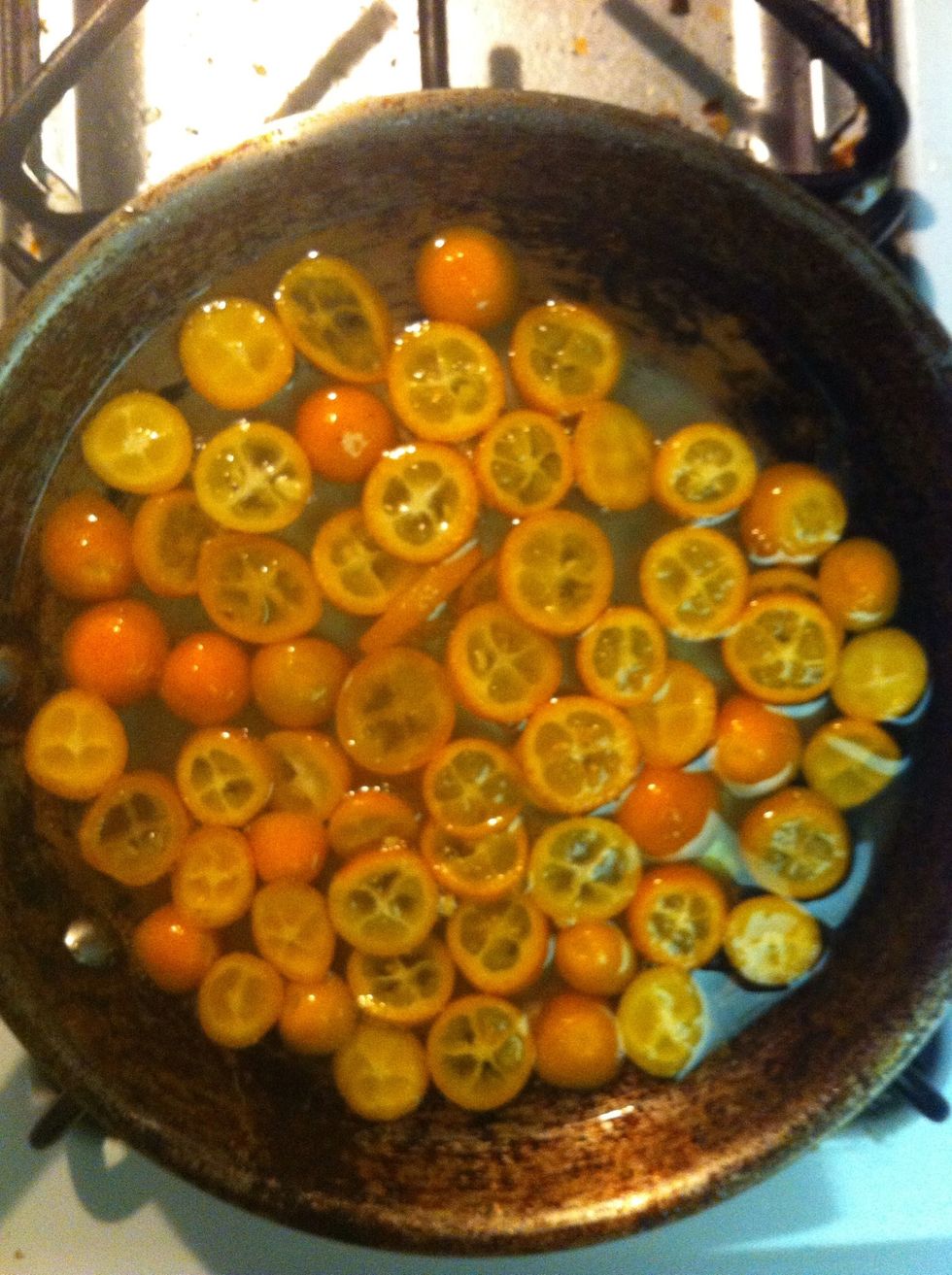 when the kumquats are tender and shiny and the sugar water is syrupy, remove kumquats with a slotted spoon and let dry in a single layer