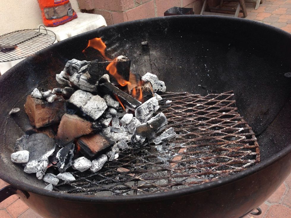 When the large flames have subsided, dump the chunks onto the unlit wood in your grill and wait about 10 minutes for it to get good and lit.