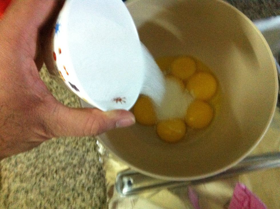 When the milk and cream begin to steam up and start to scald, add the sugar to the yolks.