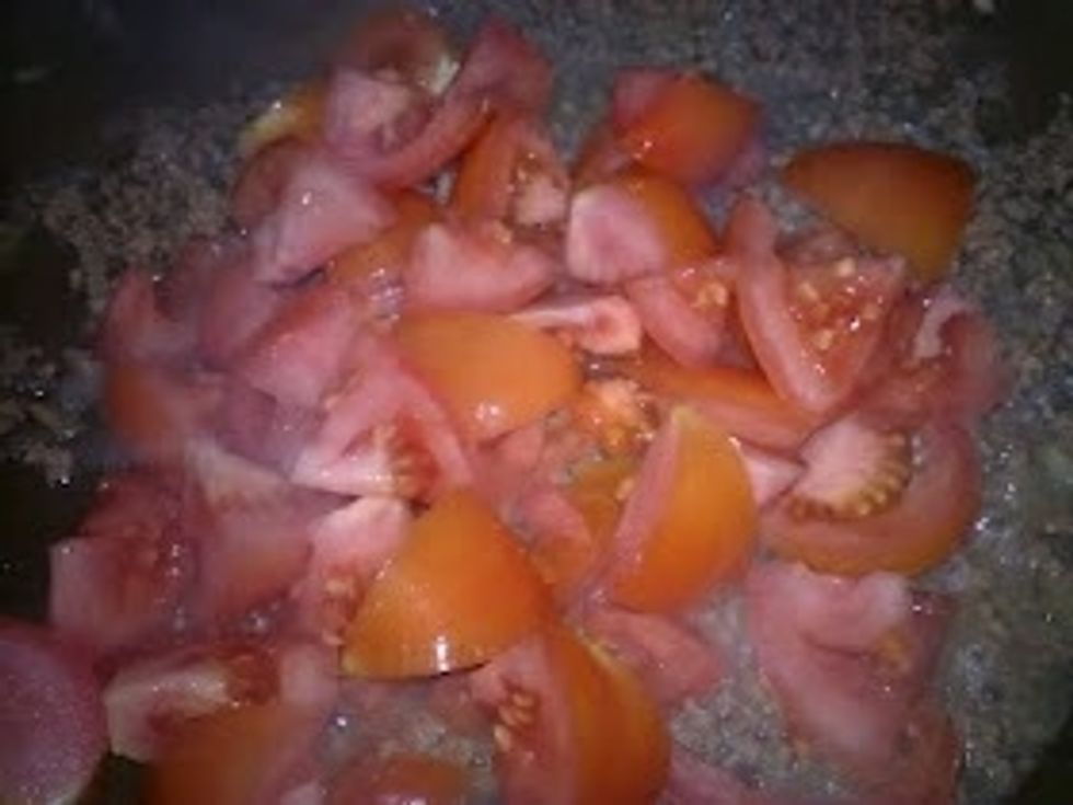 When the Minced Beef turns brown, pour the cut Tomatoes in.