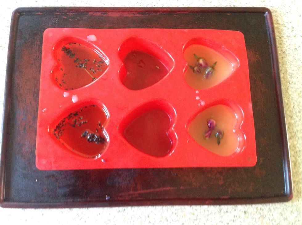 When the mixture is a bit cooler, pour into the moulds. Add dried flowers to enhance the visual effect and bath experience. I've used dried rose petal buds and lavender from my garden.