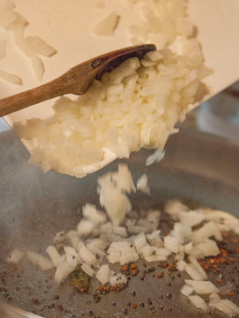 When the mustard seeds start to pop add in the chopped onion.