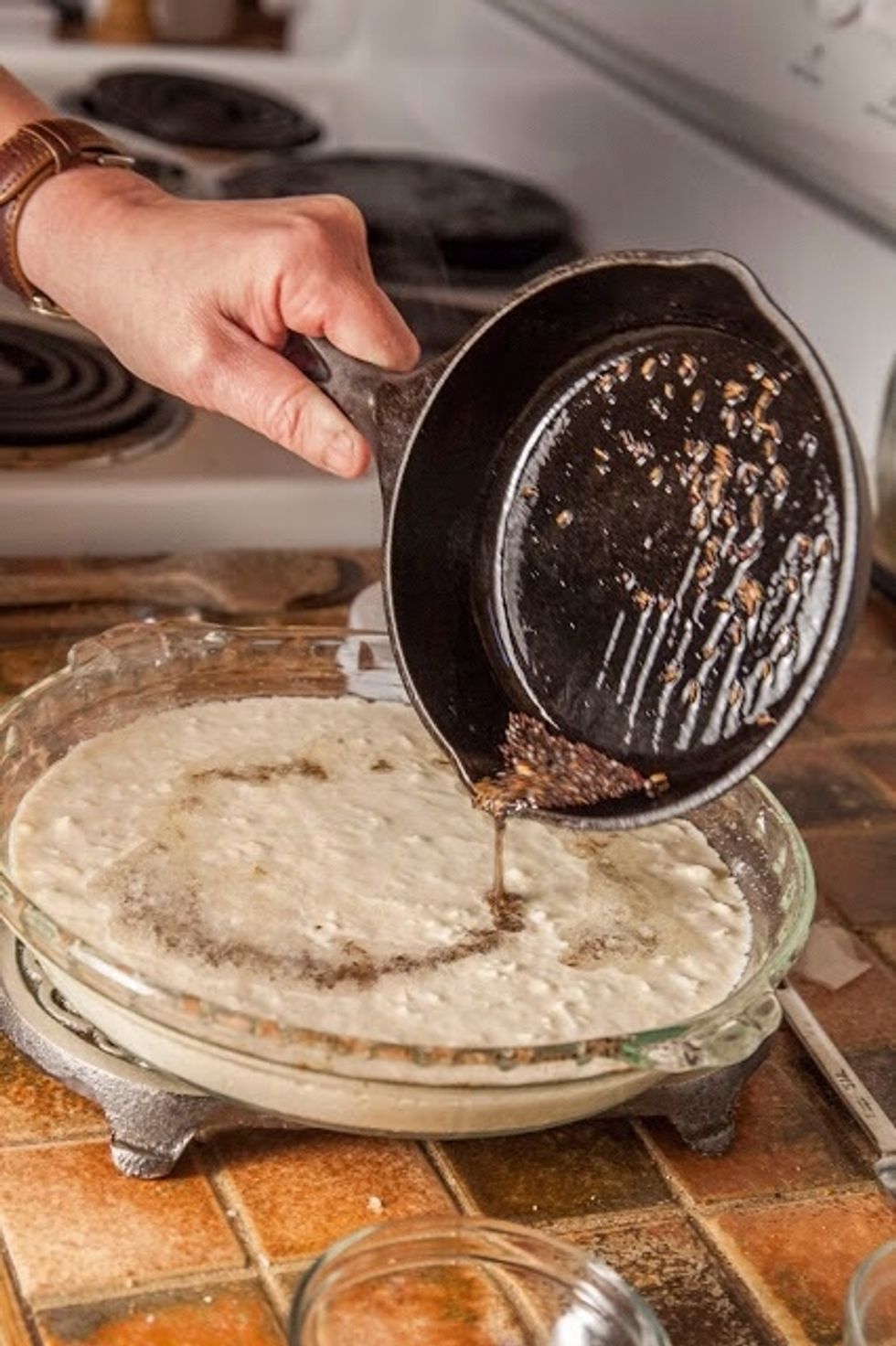 When the mustard seeds start to pop, pour over the top of the cauliflower batter.