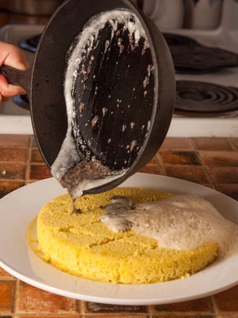 When the mustard seeds start to sizzle and pop... Pour it over the top of the cut Dhokla.
