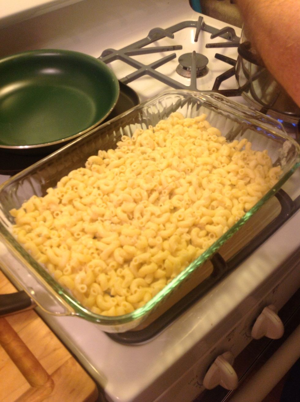 When the noodles get done, strain them, but DO NOT get rid of the onion flakes left on the strainer. Use a spatula to move all of the noodles and remaining onions into your glass baking pan.