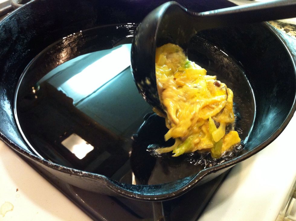 When the oil is heated up (you can check by dripping a little in, if it sizzles it's ready) then add a ladle full of the mixture to the pan.