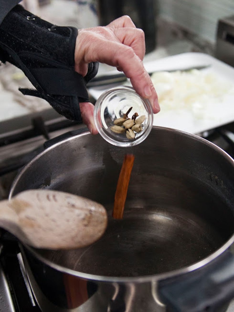 When the oil is hot add in the cinnamon stick, cloves and cracked cardamom pods.