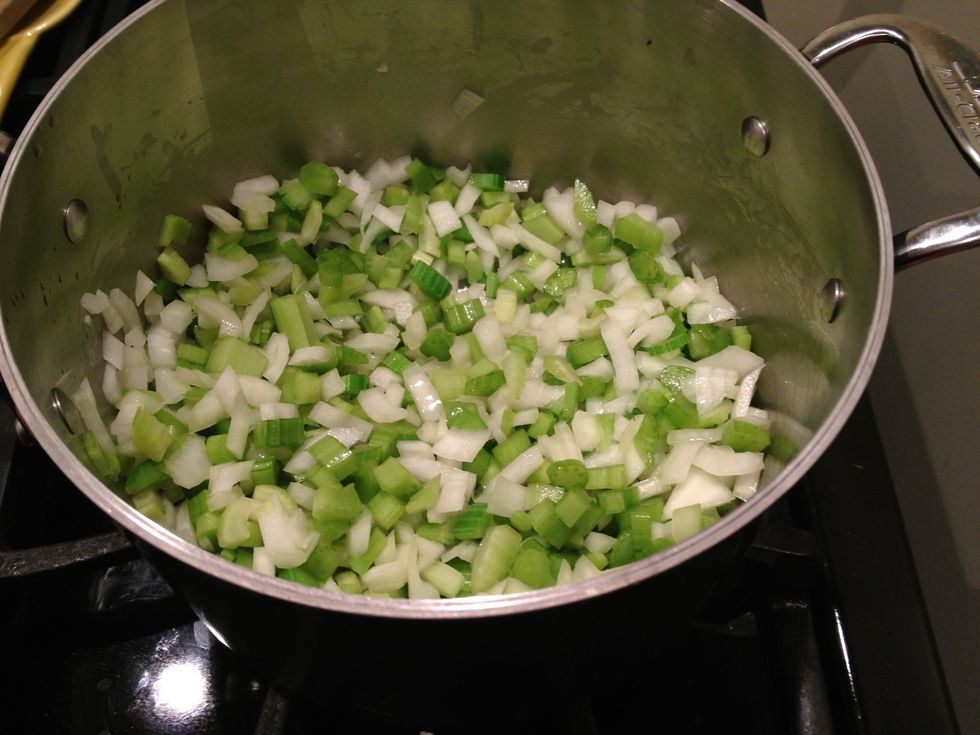 When the oil is hot, add the onion and celery. Cook, stirring periodically, until the onion is soft.