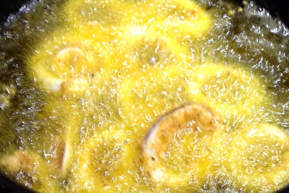 When the oil is hot, carefully drop half the squid pieces into oil. If any of the pieces stick to the bottom of the pot, loosen with tongs.