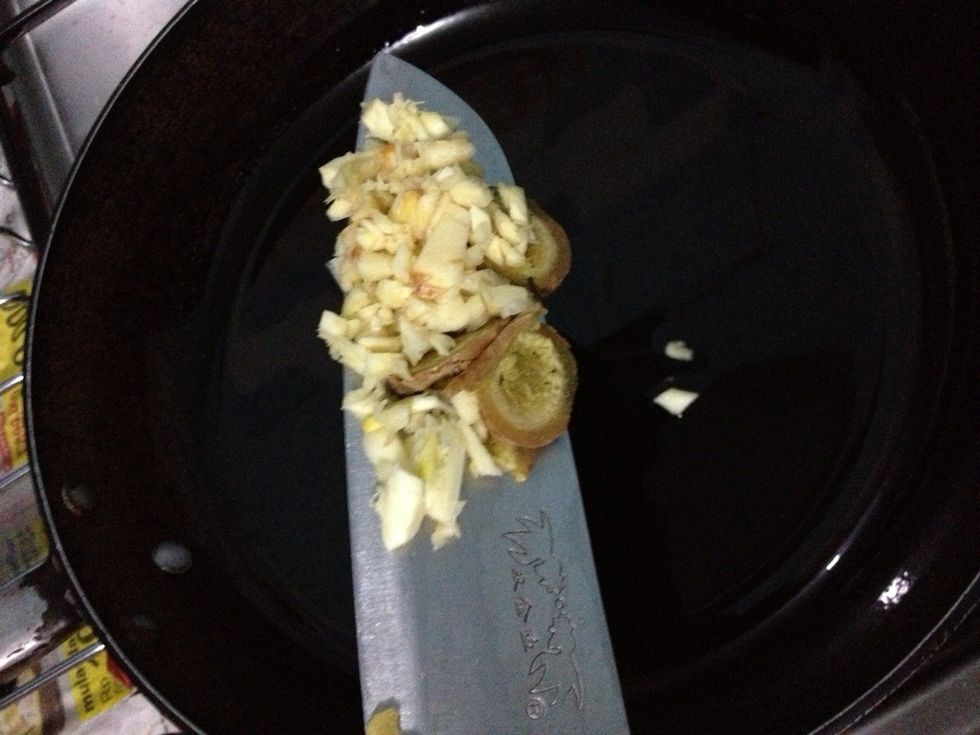 When the oil is hot enough, add in crushed and finely chopped 4 garlic cloves and sliced of 2 cm fresh ginger into the pan. Saute until fragrant