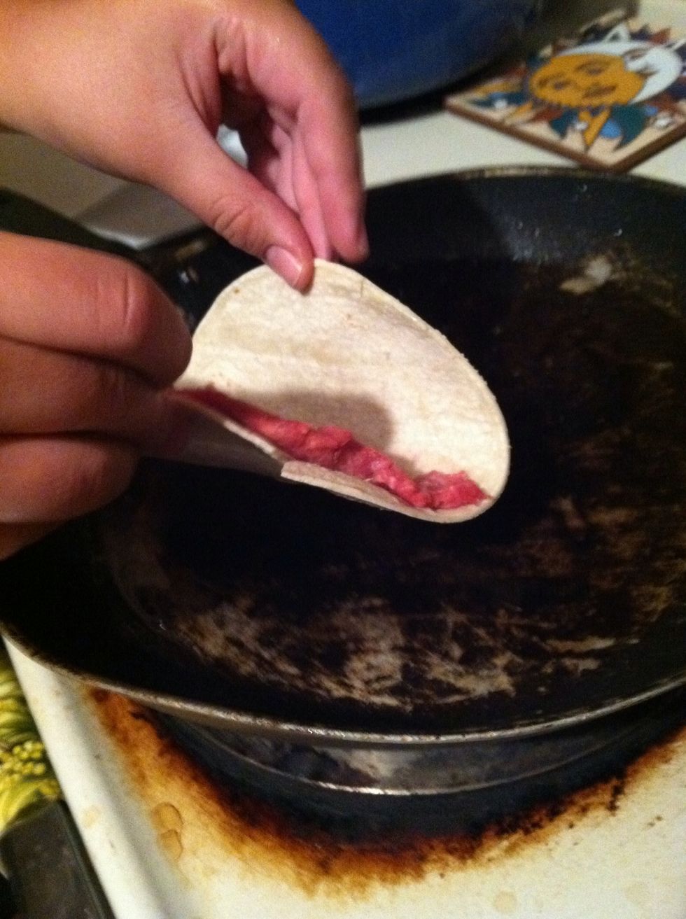 When the oil is hot enough, lay the taco in the oil like so. You want to fry the bottom so it will fold easily and not tear.