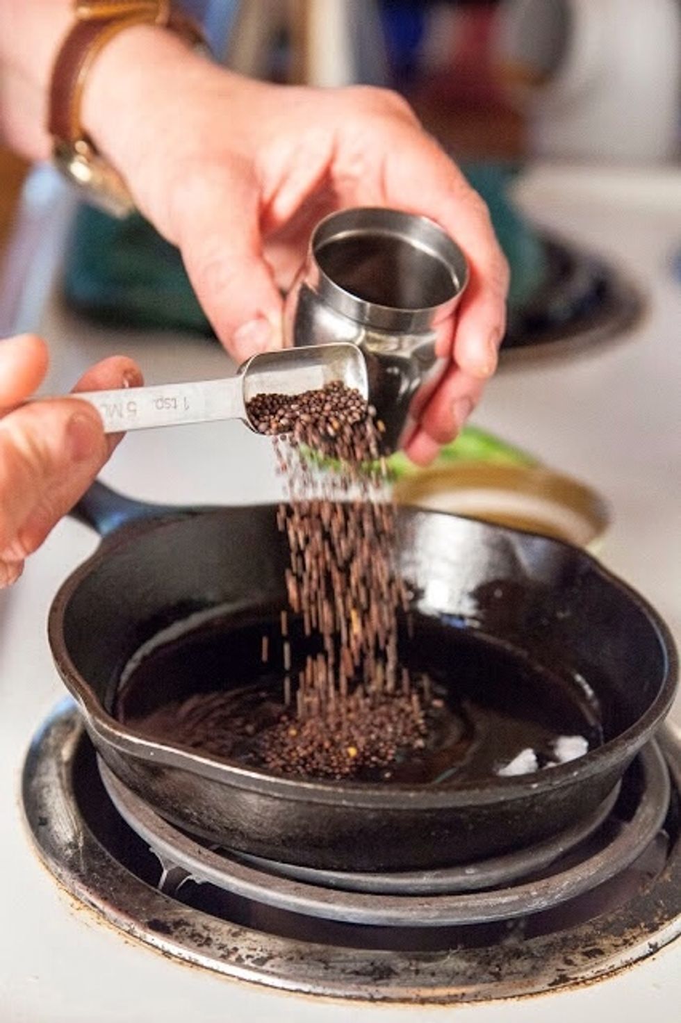 When the oil is hot, toss in 1 tsp of brown mustard seeds.