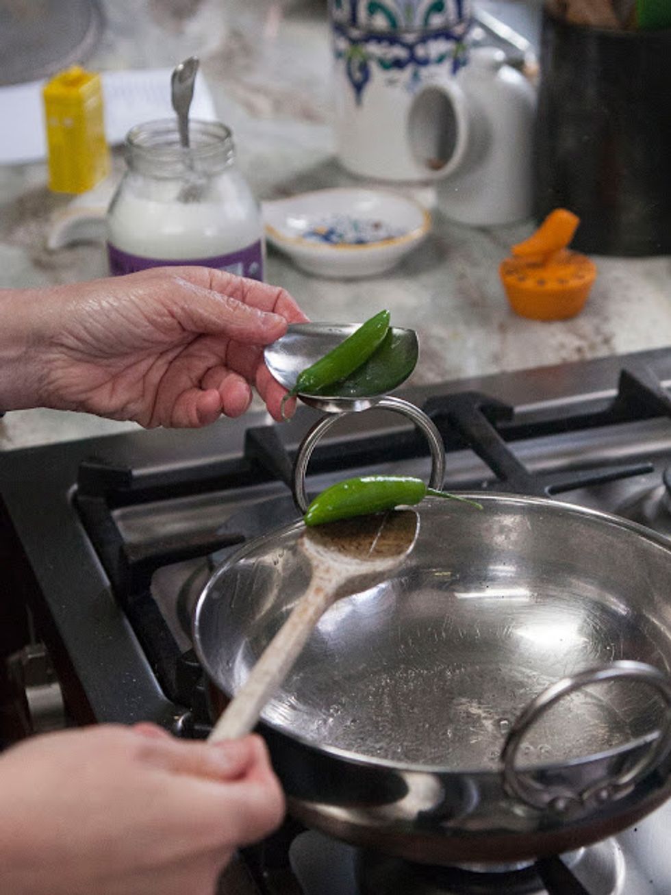 When the oil is hot toss in the 2 slit serrano chilies. Let them sizzle for about 10 seconds then take them out and set them aside.