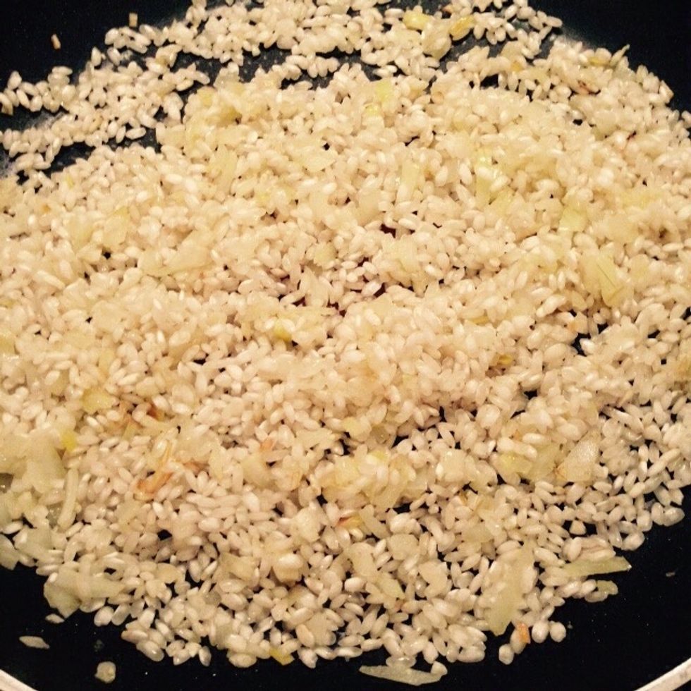 When the onion becomes translucent add the dry rice to toast it, lower the heat to avoid burning the onion.