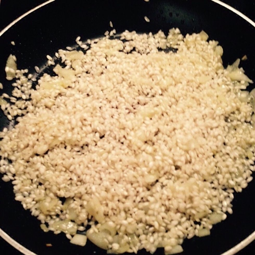 When the onion becomes translucent add the raw rice to toast it