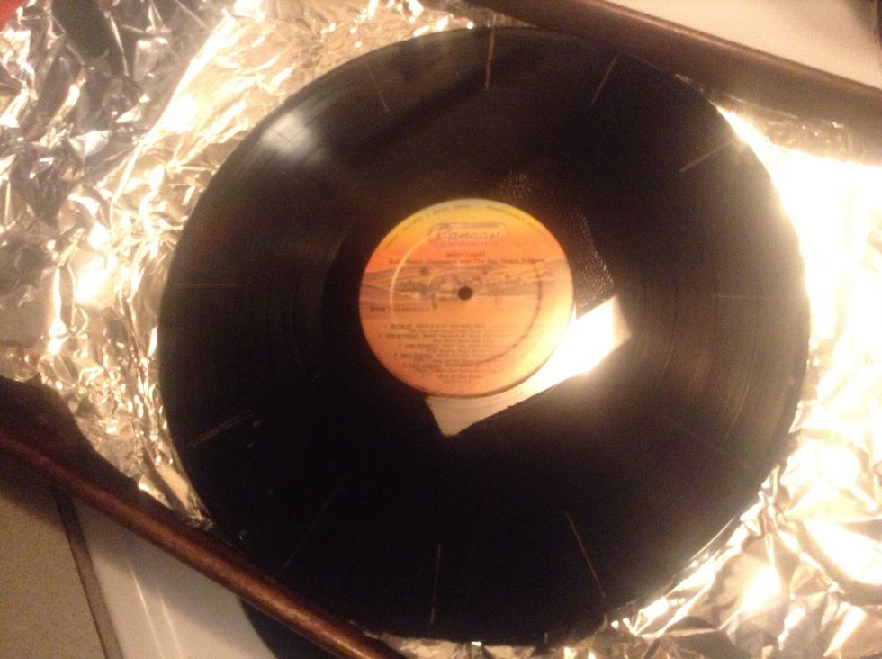 When the oven is ready, set the record on the pan and put it in the oven for about 10 seconds. The record begin to bend and look somewhat floppy; this is when you are supposed to take it out.