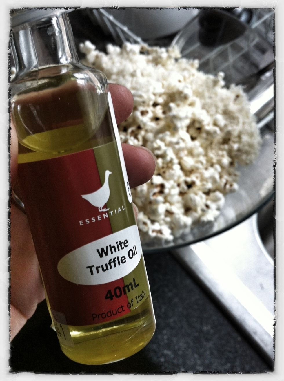 When the popping stops, tip popcorn into a bowl and drizzle half a teaspoon of truffle oil over, mixing well. If you have an oil mister, even better!