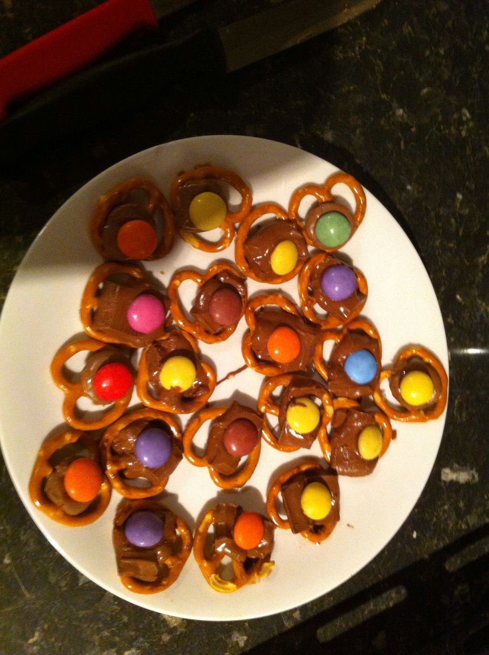 When the pretzels and chocolates come out the oven and the chocolate is melted, press a smartie into the chocolate