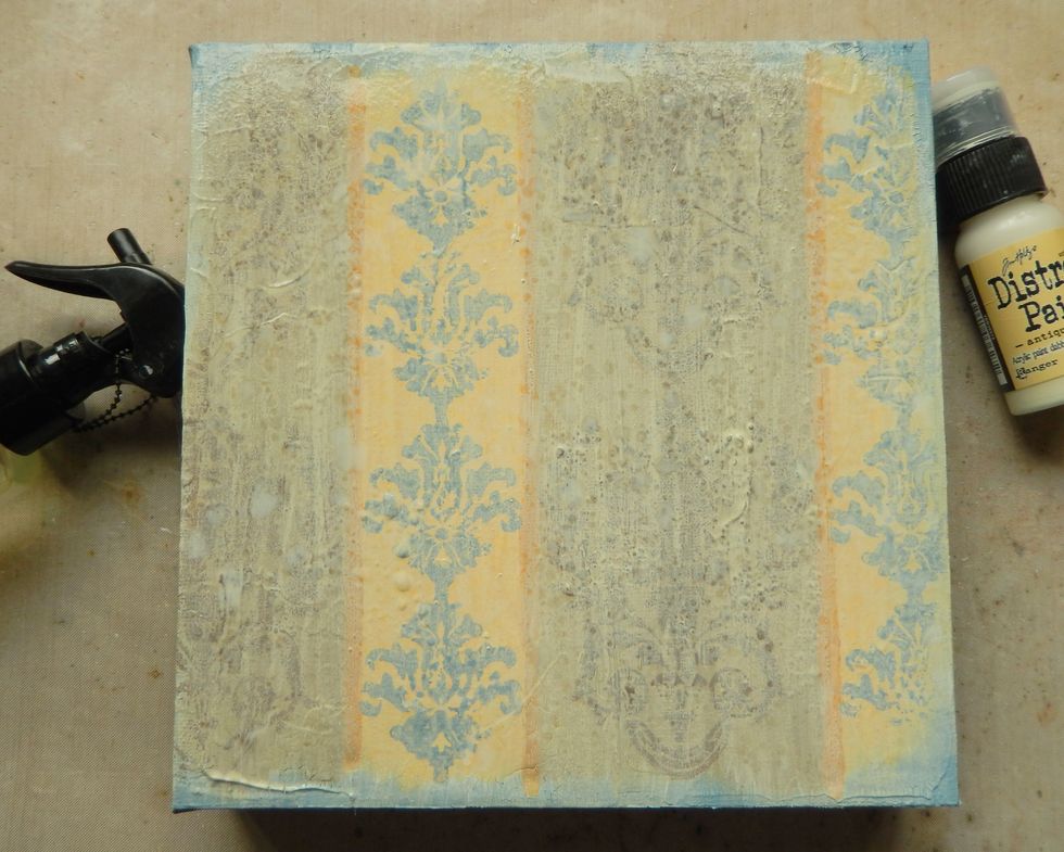 When the previous layers are dry paint over with Antique Linen Distress Paint, dripping lots of water over the top immediately. Start to dry the paint with your heat gun but don't heat set completely.