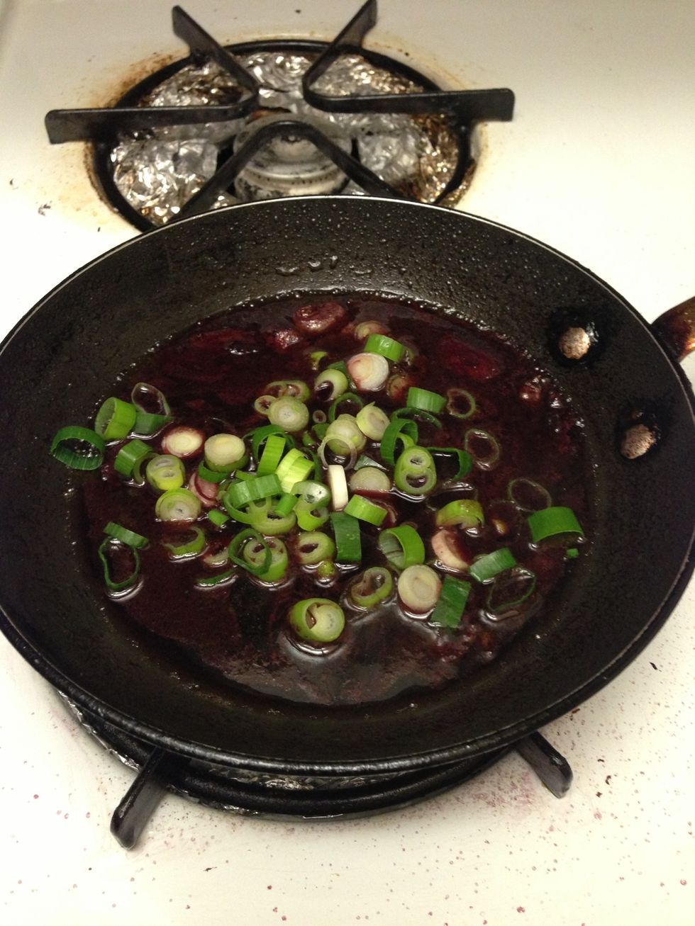 When the reduction as reached about 25% of its original volume, add green onions and remove from heat. Allow  sauce to thicken for 5 minutes.