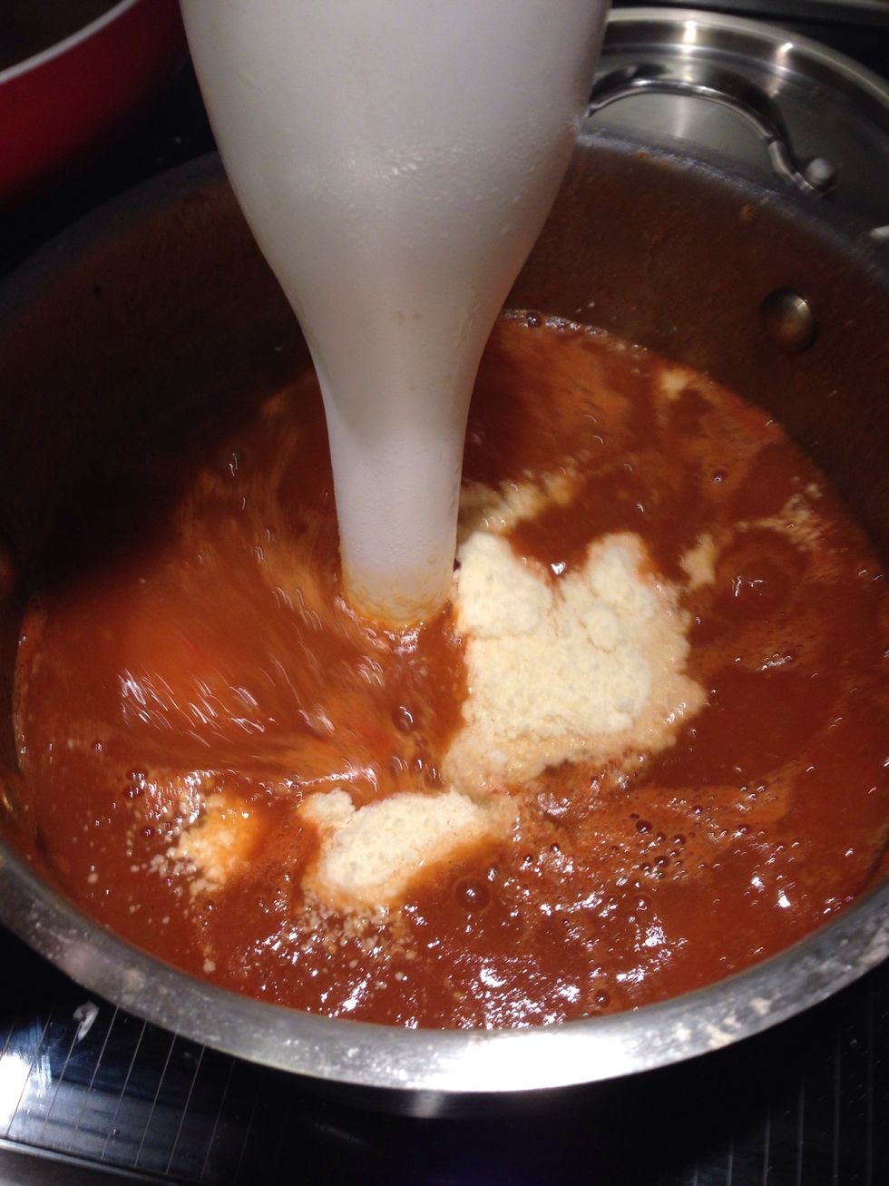 When the tomatoes and onion are boiled and soft add the Parmesan and blend with a hand blender. Make sure to take out the cloves before blending!