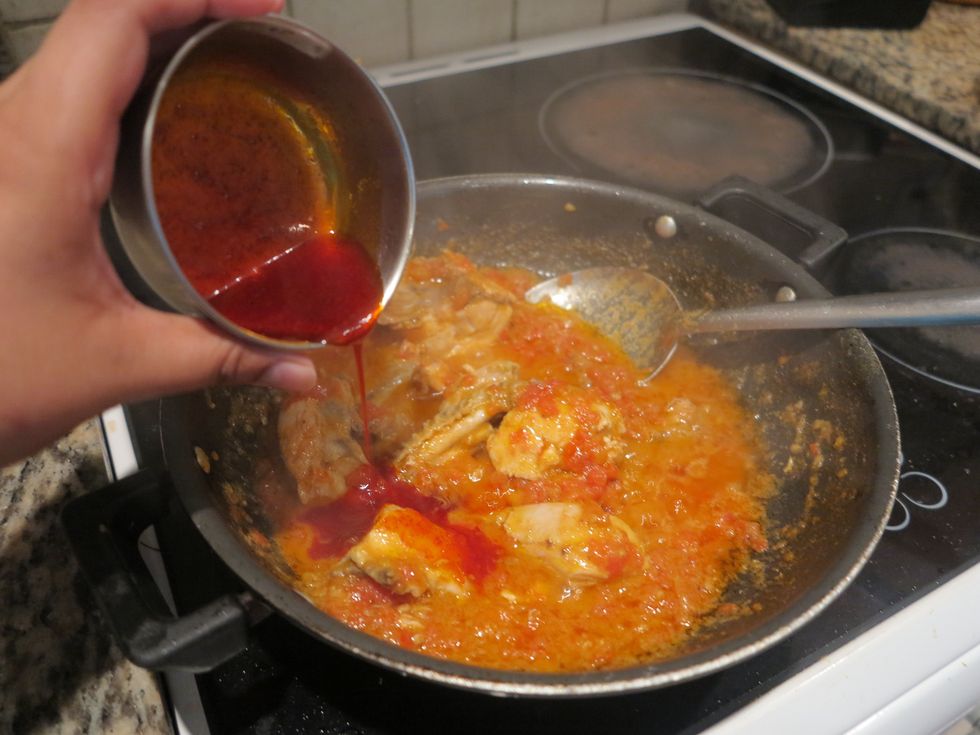 When the tomatoes start to turn a little mushy and the water consistency goes down a bit, add the oil and powder mixture prepared and mix to infuse the color and flavour. Add some water if necessary.
