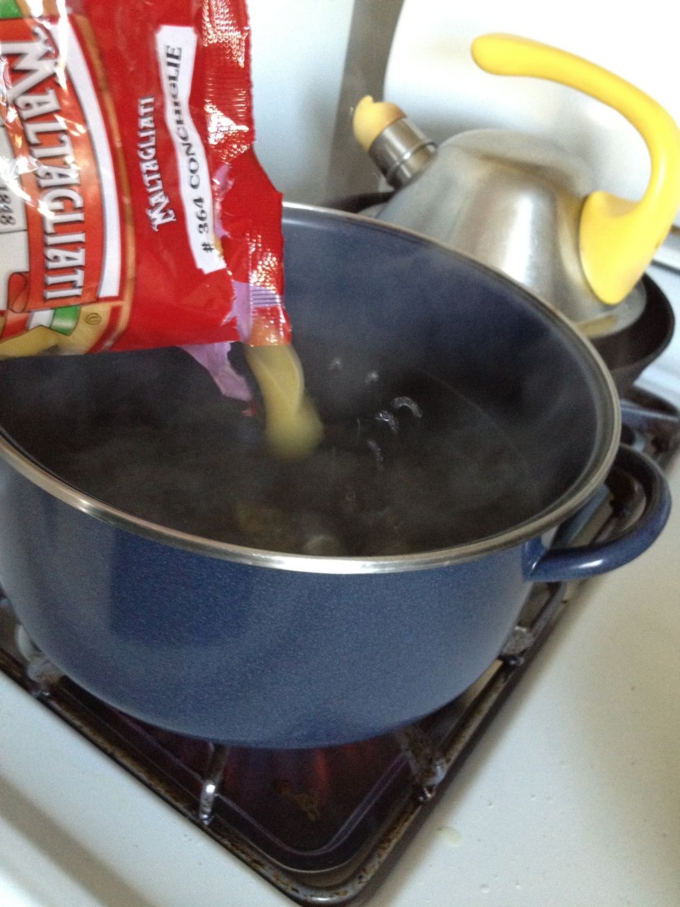 When the water boils, add your pasta (Just using one half bag here). You can use any type - I'm using shells because I like the way the bacon goes into the little pockets. Fettuccine is also used.