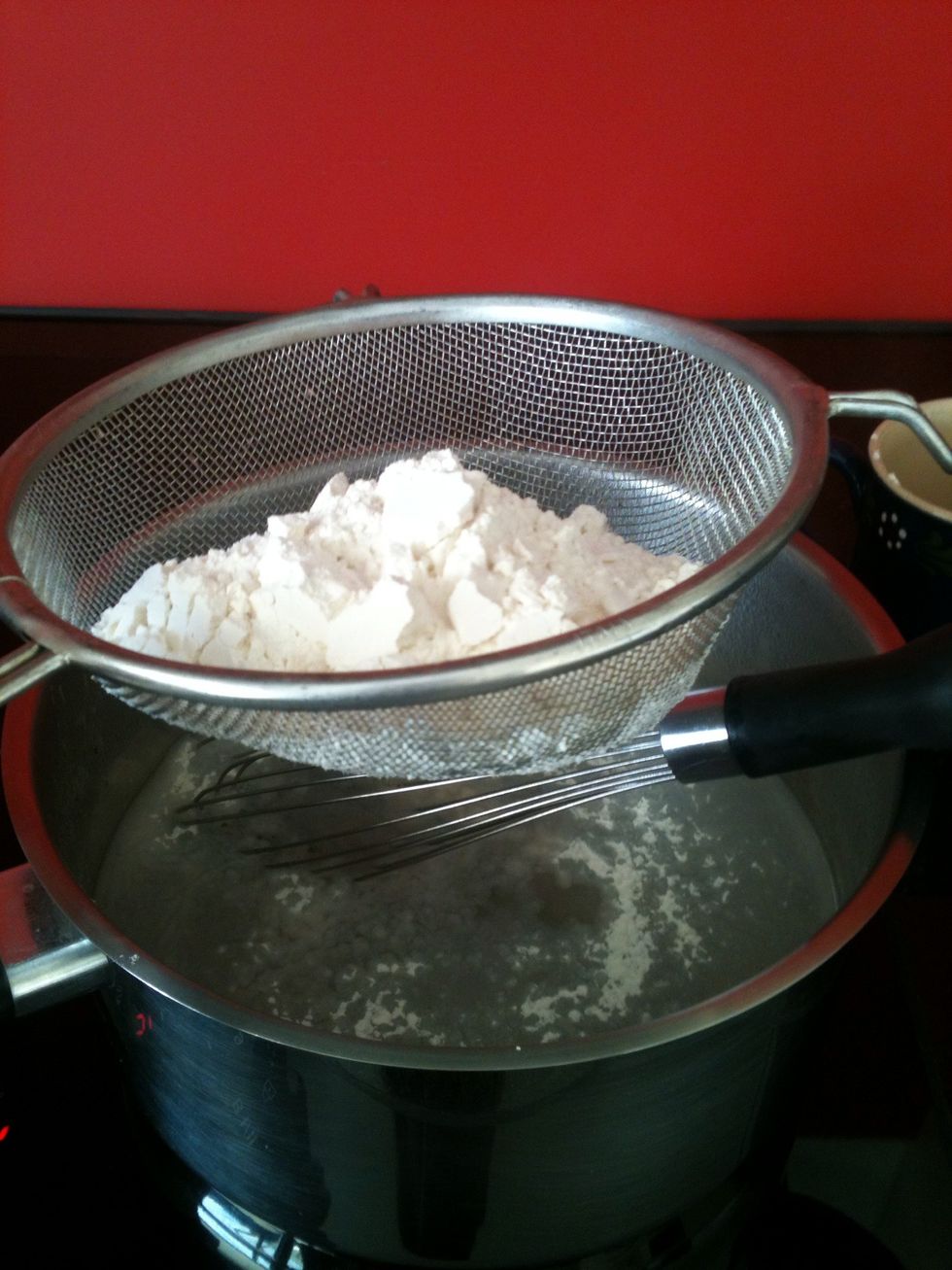 When the water boils, take it off the hotplate and add the flour. (It works better if you sieve the flour). Then stir it with a whisk until you have a thick mixture.