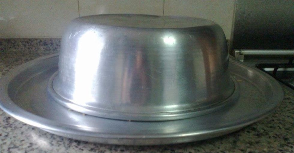 When the water is absorbed and the rice is cooked ,set a plate or platter over the top of the pot ,and flip it upside down