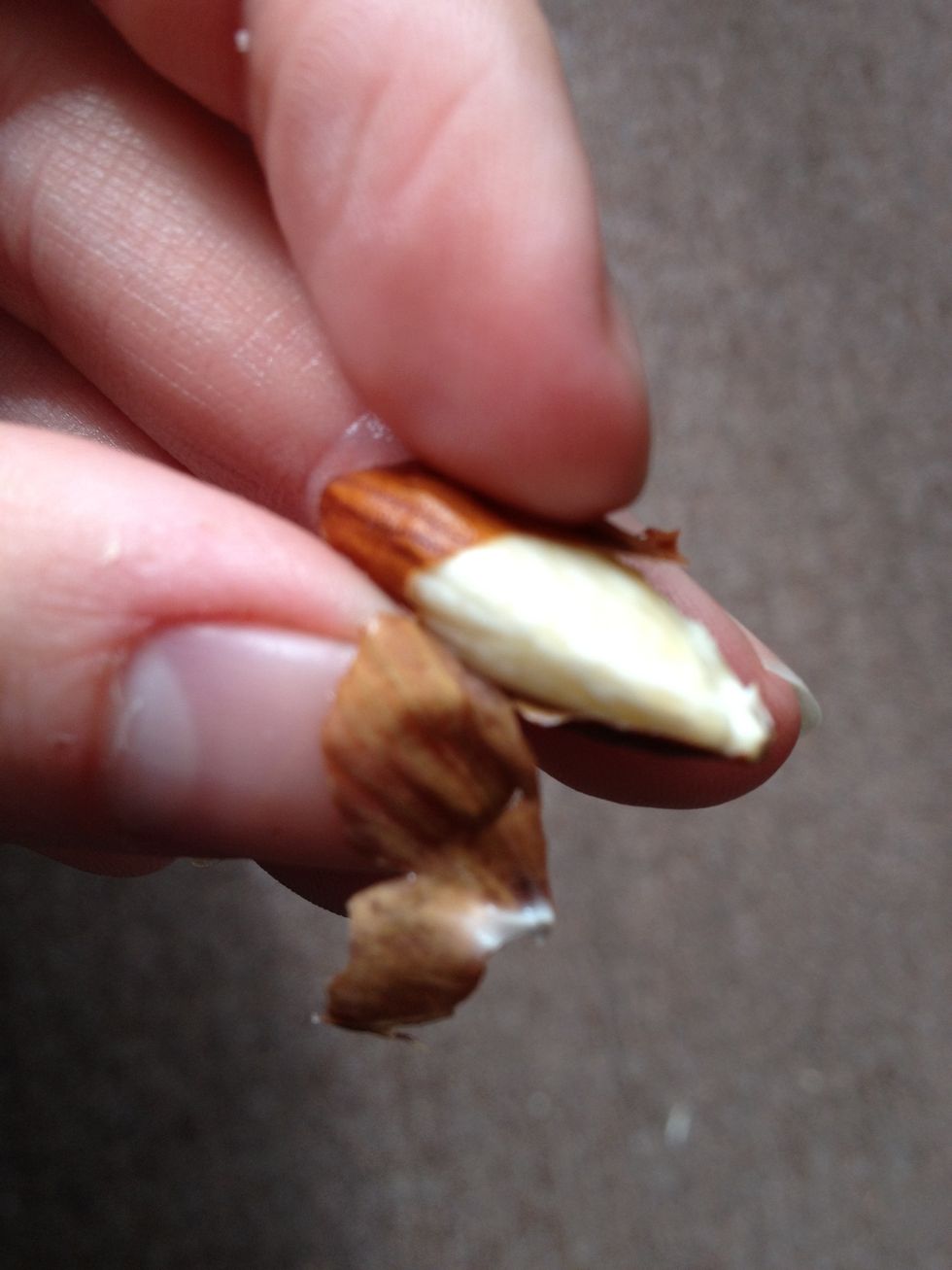 When the water is cool enough, you should be able to roll the almond in your fingers and get the skin off. It should feel more pliable, and you should be able to feel it rolling off the nut