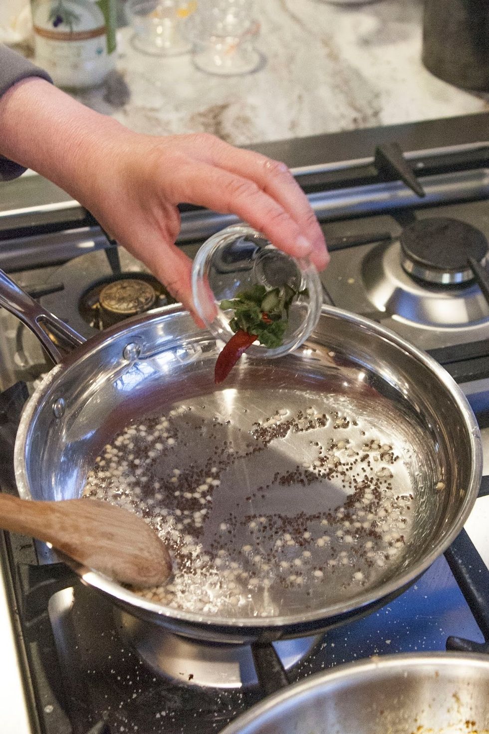 When they start to sizzle and pop, toss in the dried red chili.and curry leaves.
