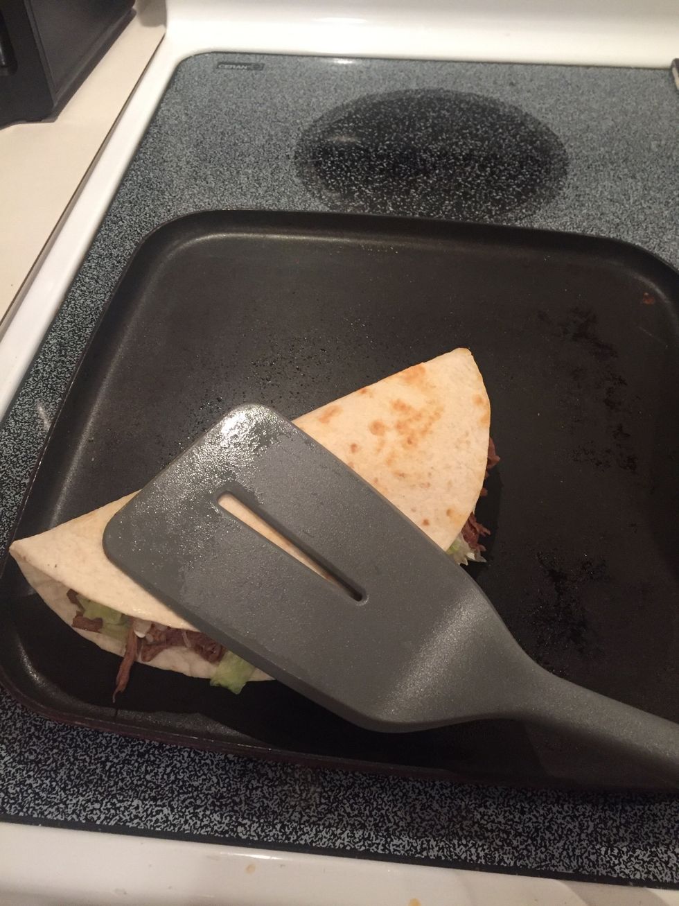 When tortilla starts to brown and harden, flip one slide and press down. Be careful not to burn the tortilla!