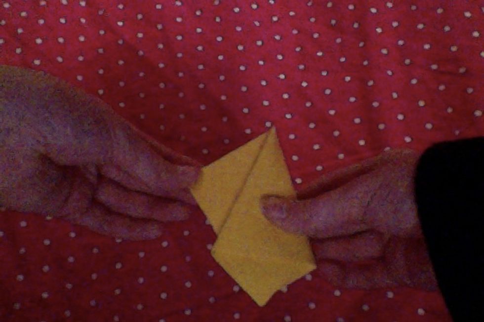 when turned over, you should see an extra triangular flap like this. Turn your paper back around for the next step.