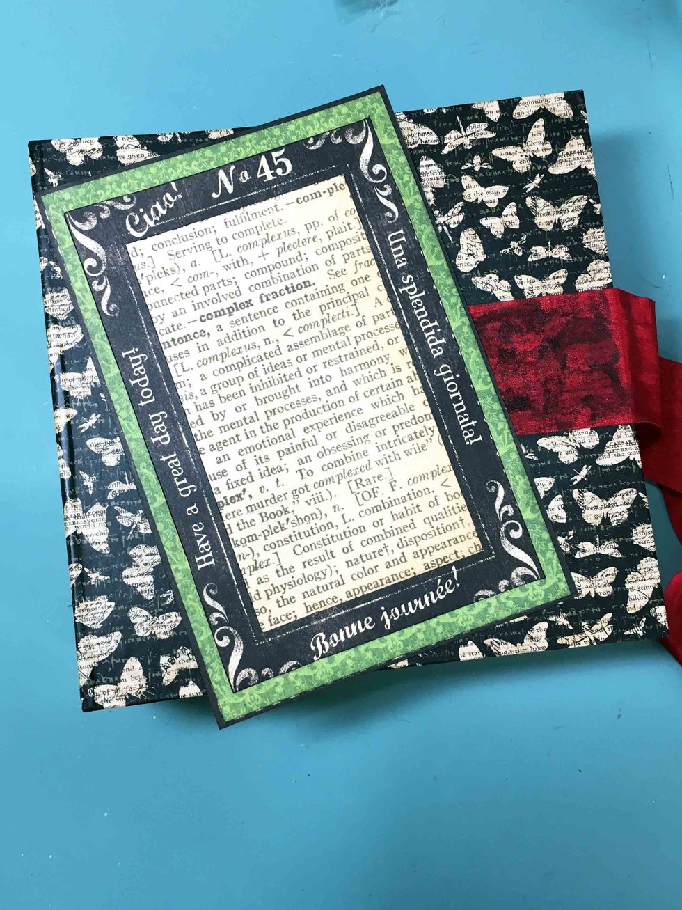 When using Matte Medium, be sure to coat both the mini and the paper to get a good seal. Place the frame on the front cover and carefully holding it in place turn the cover to the inside.