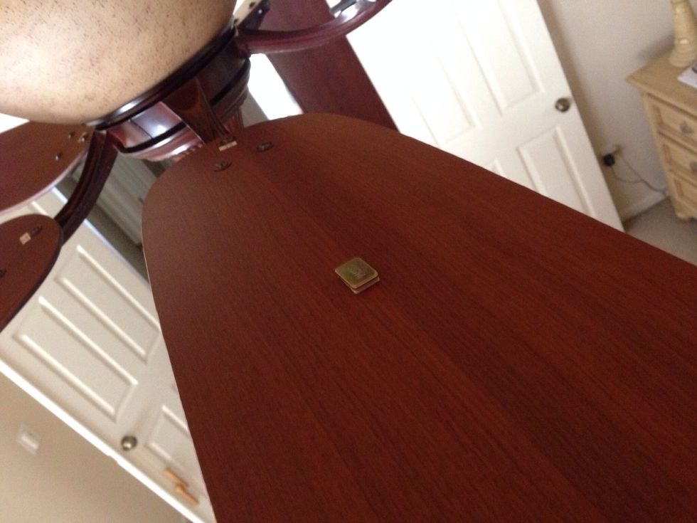 When you find the blade that accepts the weight by eliminating wobbling, remove the clip and add the stick-on weight to the center of that blade on the top unseen side.