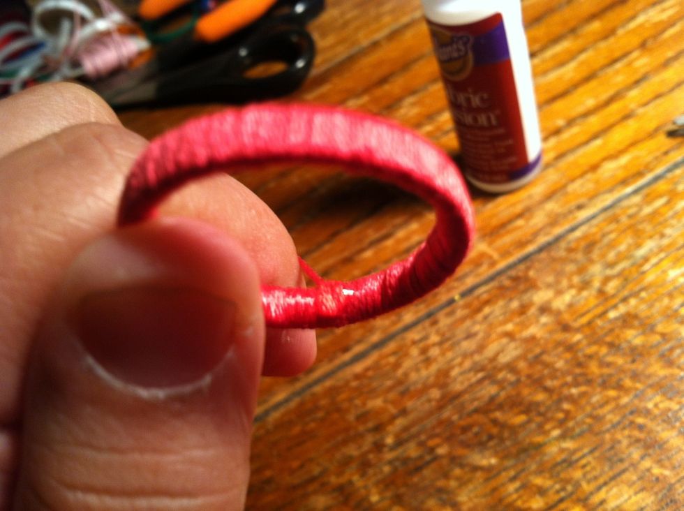 When you have covered the last bit of plastic pull your string tight and place a small dab of glue on the inside. Snip the string flush and smooth the glue over the end.