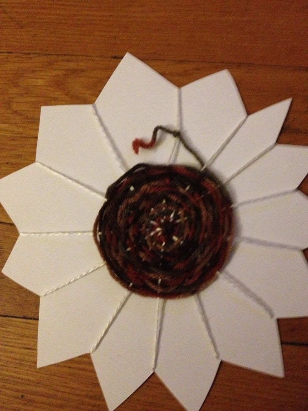 When you have finished weaving, tie the brown yarn to one of the yellow spokes.