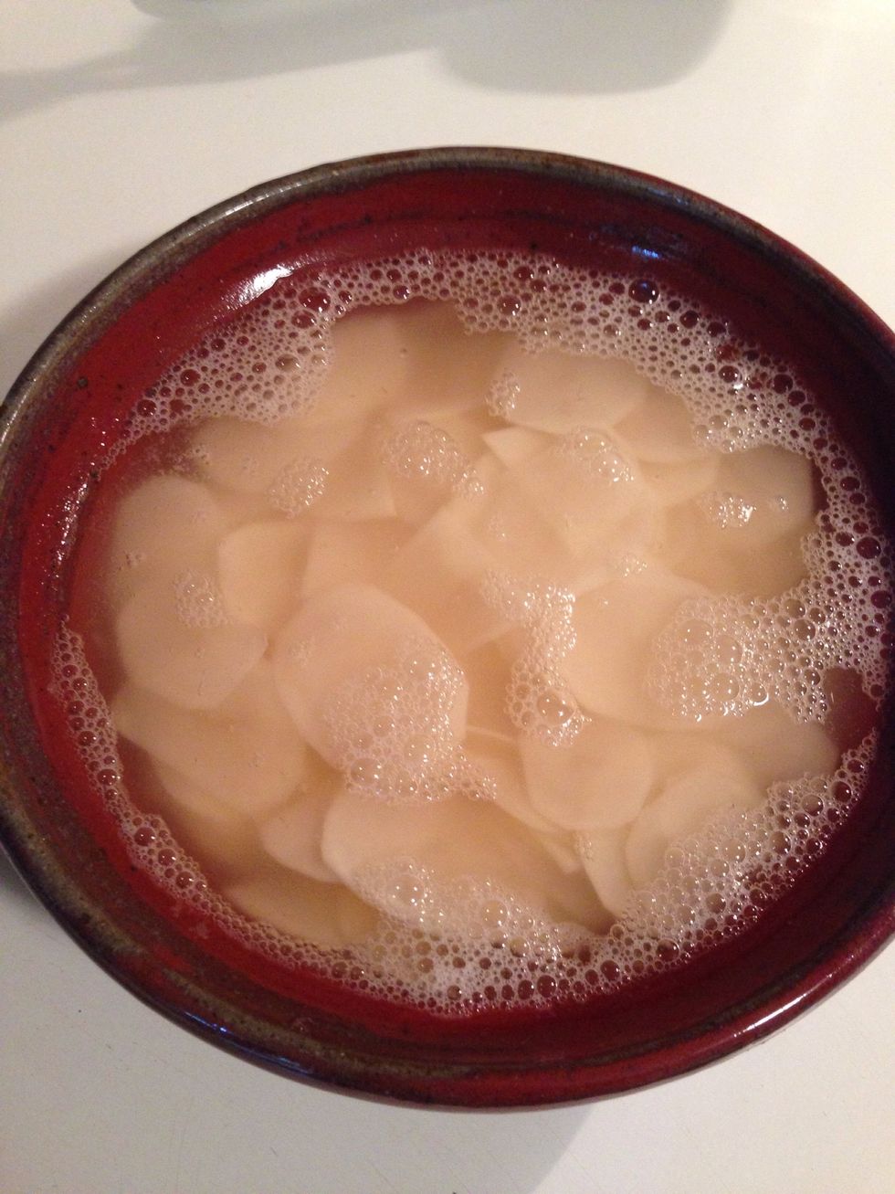 When you're done slicing, place chips in a bowl full of water. This is going to help pull some of the starch out of the potato slices. Cover and let sit for a couple hours.