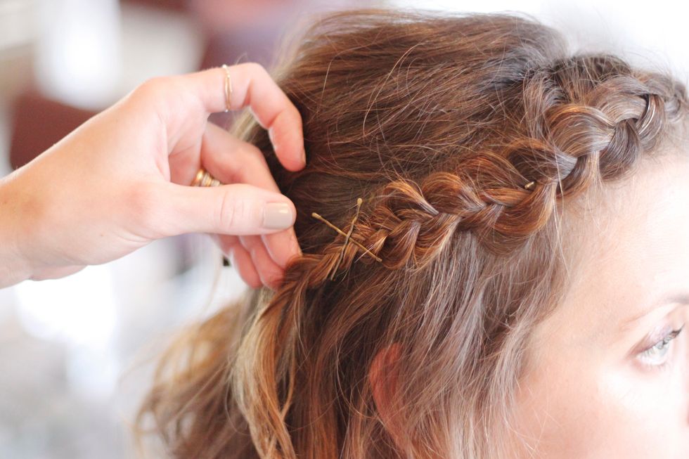 When you're happy with its placement, take the end of the braid and secure it just above and behind the ear with two crossed pins.