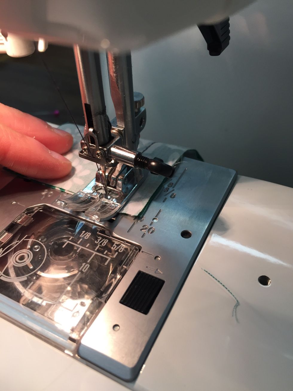 When you reach the end of the fabric, REVERSE (press and hold reverse control) 3 stitches and then go forward to the end.