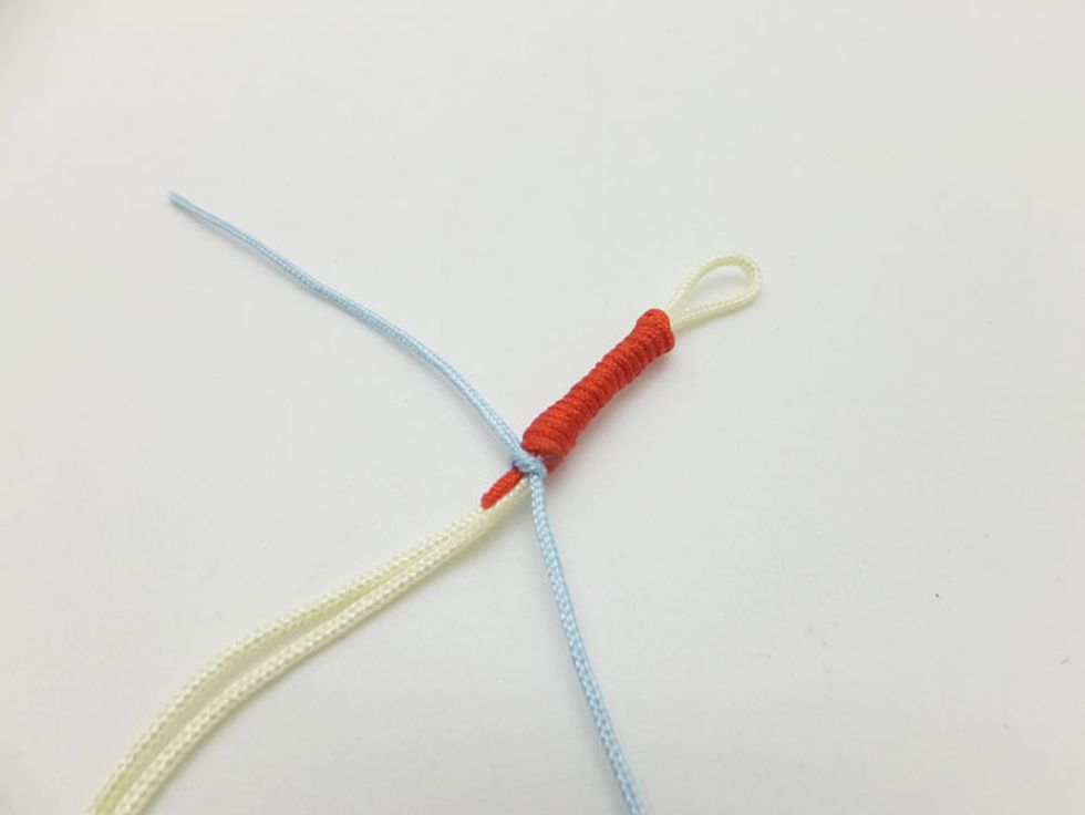 When you reach the length that about 2cm on your bracelet, tie a small knot with a 50cm sky blue cord in case the red cord loosed off.