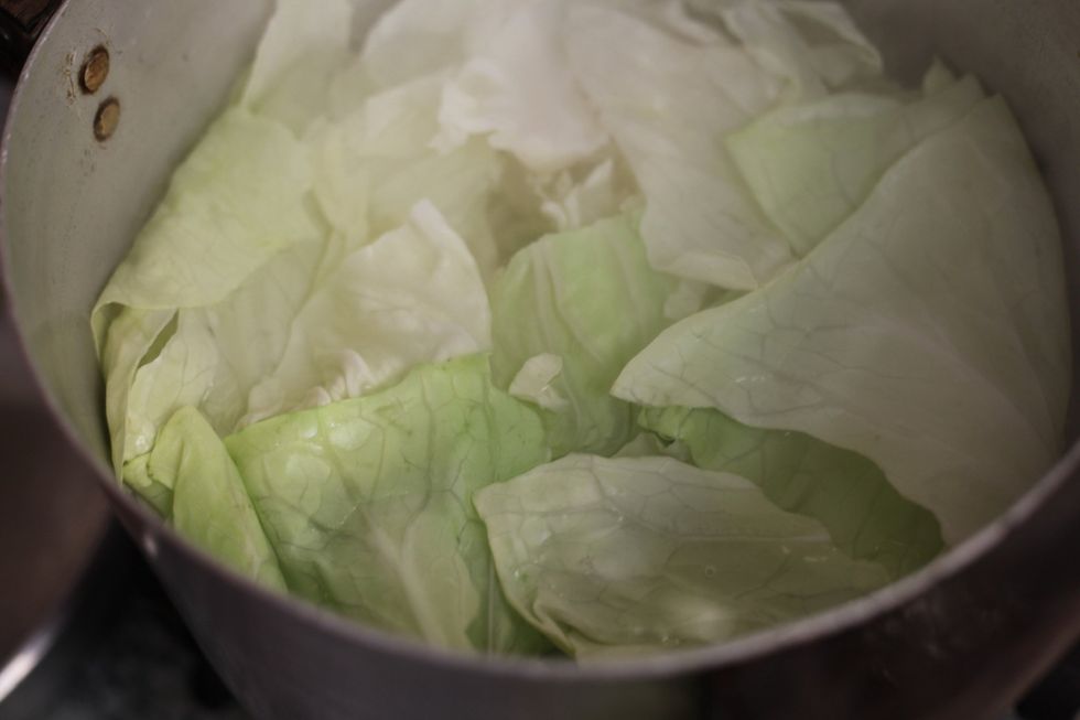 When you start to see the leaves' veins becoming clear, remove and drain the water. Leave them aside to cool down. We'll work on our filling.