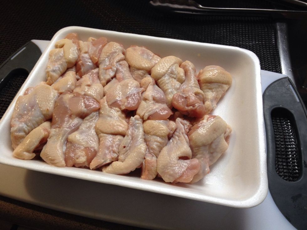 When your all set up, take out your wings and start rubbing them into your flour mixture.