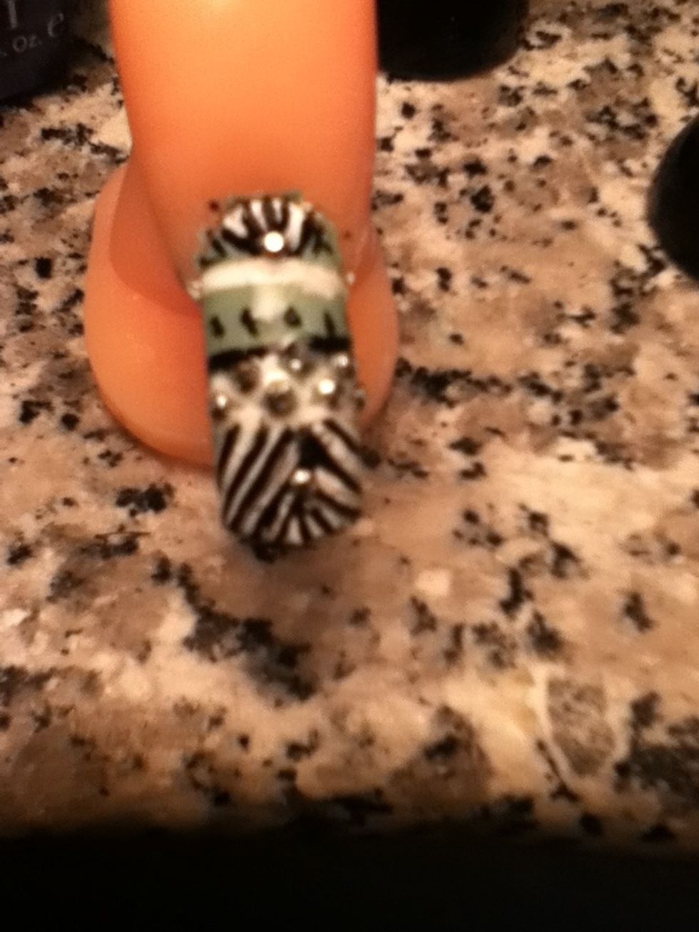 When your done with the lines then add the little silver beads bt the zigzagg's in between the lines then one on the top of the nail and bottom.