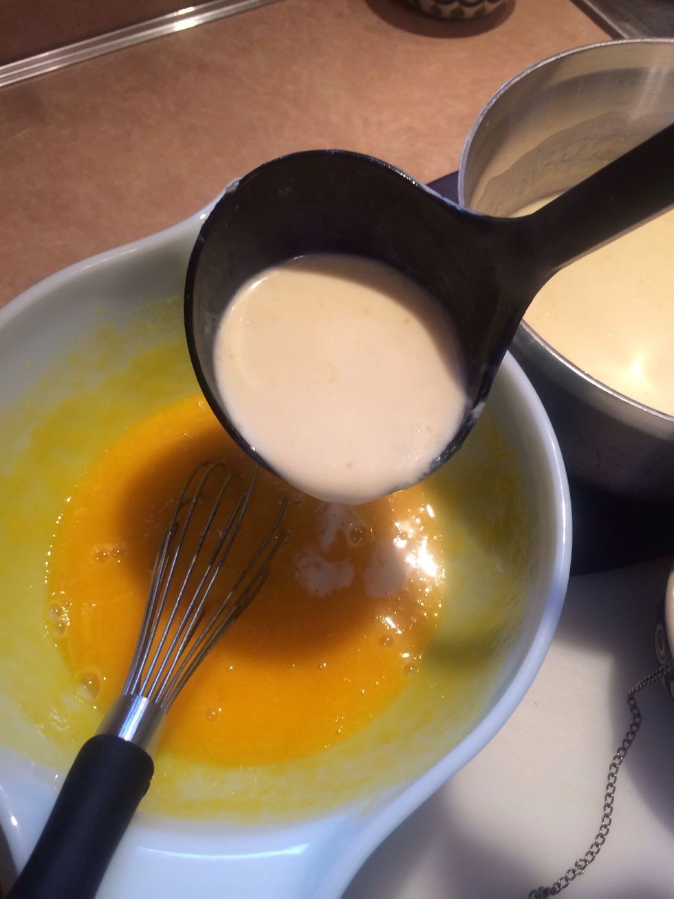 While adding a ladle of of hot cream to the cool egg mixture whisk constantly.