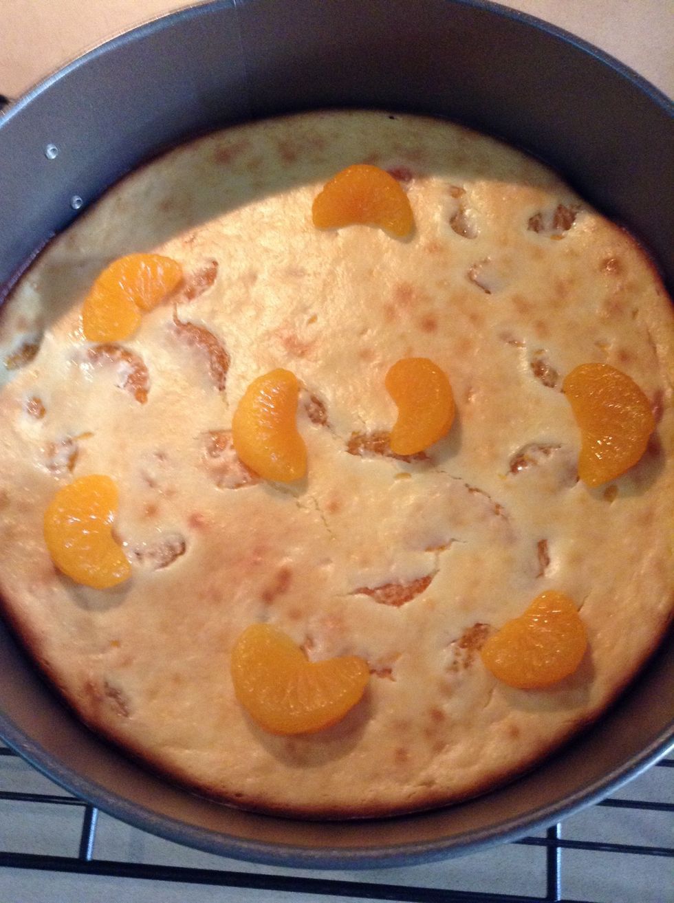 While chocolate is melting put the Mandarin oranges on the cheese cake